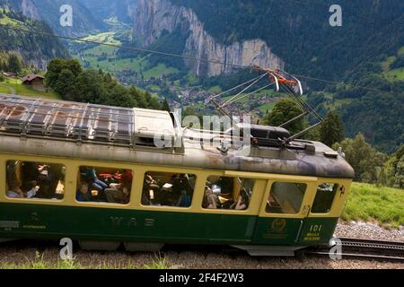 The spectacular Lauterbrunnen valley with the Wengernalpbahn rack and pinion railway approaching Wengwald in the foreground, Bernese Oberland, Switzer Stock Photo