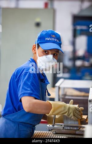 Taldykorgan, Kazakhstan - June 06 2012: Accumulator recycling plant Kainar. Young Asian worker woman sorting plumb storage battery plates. Stock Photo