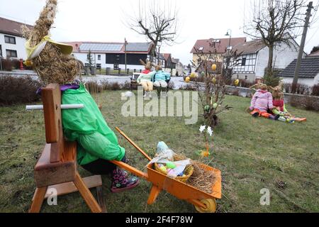 Brausndorf, Germany. 21st Mar, 2021. Easter bunnies made of straw and colourfully painted Easter eggs on a bush can be seen in the village square. Credit: Bodo Schackow/dpa-Zentralbild/dpa/Ģ����ý Live News Stock Photo