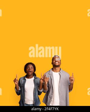 Great Offer. Surprised Black Couple Looking And Pointing Up With Amazement Stock Photo
