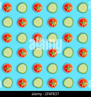 Top view of cucumber slices and red cherry tomatoes isolated on blue background Stock Photo