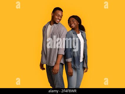 Cheerful black man and woman turning heads to each other Stock Photo