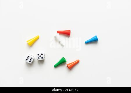 Multi-colored playing chips and dice cubes are grouped together on a white background: the concept of Board games, entertainment, background, games at Stock Photo
