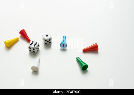 Multi-colored playing chips and dice cubes are grouped together on a white background: the concept of Board games, entertainment, background, games at Stock Photo