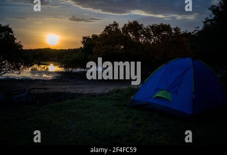 Moon setting and its reflection while camping Stock Photo