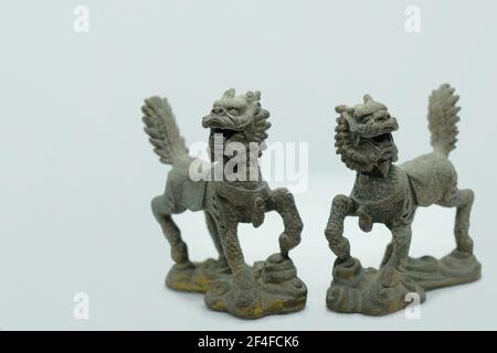 A pair of mythical Chinese bronze Qilin figurines, with head of a dragon, antlers of a deer, skin and scales of a fish, hooves of an ox & lion's tail Stock Photo