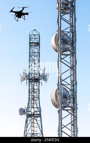 Antenna Calibration with drone. Telecommunications towers with blue clear sky Stock Photo