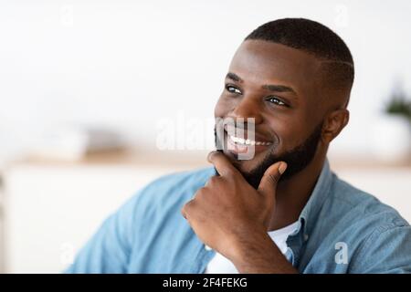 Portrait Of Handsome Smiling African American Man Touching Beard While Looking Away Stock Photo