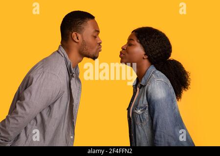 First Kiss. Romantic black couple reaching out each other for kissing Stock Photo