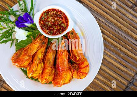 Thai food, Fried tiger prawns with garlic - The most delicious seafood dishes in Thailand. Top view and close up on a wooden table. Stock Photo