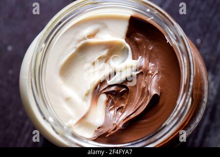 Brown and white chocolate spread in a jar close up Stock Photo