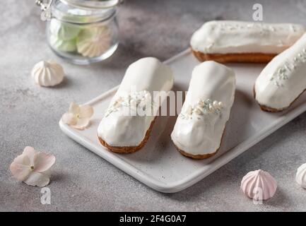 white glaze eclairs on white serving board Stock Photo