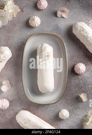 delicious white chocolate eclairs on flowers background Stock Photo