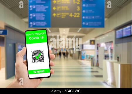 Traveler hand hold phone with health passport of vaccination certification. Health pass on phone at airport have been vaccinated of coronavirus covid- Stock Photo