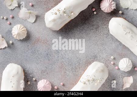 frame composition with white glaze eclairs, sweets, flowers Stock Photo