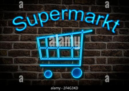 Leuchtreklame mit der Aufschrift Supermarkt, ein Einkaufswagen befindet sich unterhalb der Neon-Schrift | Illuminated advertisement for a Super Market Stock Photo