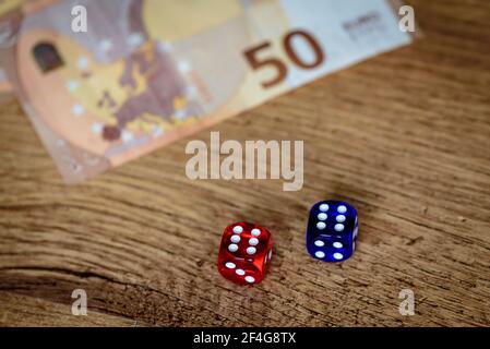 several colored dice and euro money for gambling winnings and gambling that makes you feel rich and rich Stock Photo