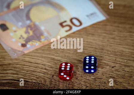 several colored dice and euro money for gambling winnings and gambling that makes you feel rich and rich Stock Photo