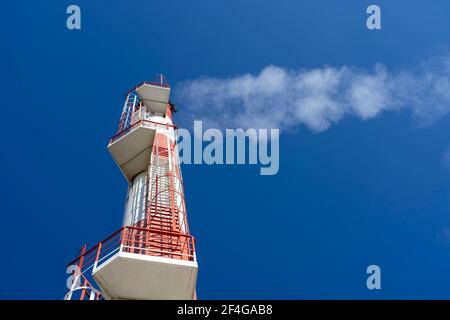 Close Up Shot of Smoke Coming Out from Power Plant Chimney.District Heating Plant Exterior With Industrial Chimney Against the Blue Sky.Low Angle View. Stock Photo
