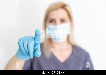 healthcare, medicine and technology concept - smiling female doctor without stethoscope pointing to something or pressing imaginary button Stock Photo