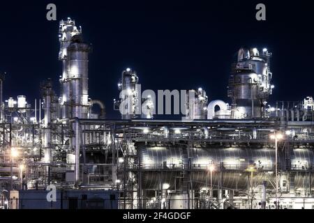 Industrial pipelines of an oil refinery power station at night Stock Photo