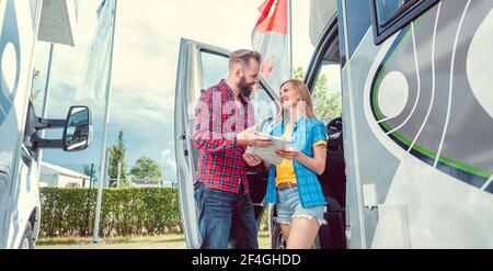 Couple choosing their next vacation route on map on yard of rv dealer Stock Photo