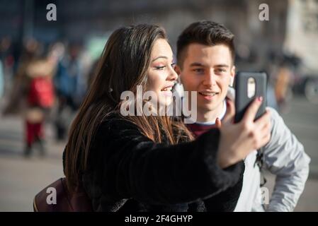 Couple of turists taking a selfie in an European city Stock Photo