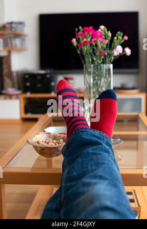 Feet in red socks resting on the table. Close up. Resting concept. Stock Photo