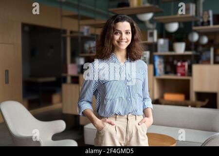 Young latin girl student looking at camera standing in university campus. Stock Photo