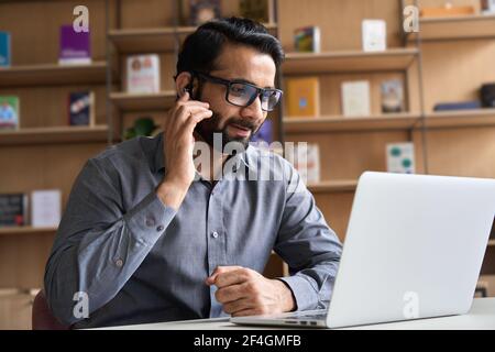 Indian customer support manager wearing headset consulting client on video call. Stock Photo