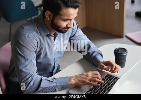 Indian business man working or studying typing on laptop at home office. Stock Photo