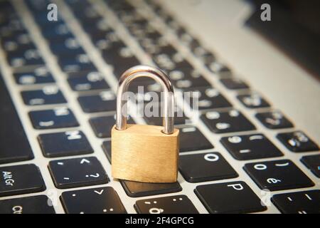 Computer security concept. Unlocked padlock on notebook keyboard. Symbol of safe. Selective focus Stock Photo