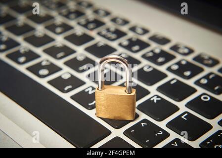 Computer security concept. Unlocked padlock on notebook keyboard. Symbol of safe. Selective focus Stock Photo