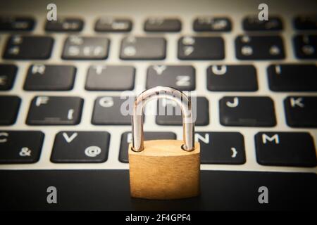 Computer security concept. Unlocked padlock on notebook keyboard. Symbol of safe. Selective focus Stock Photo
