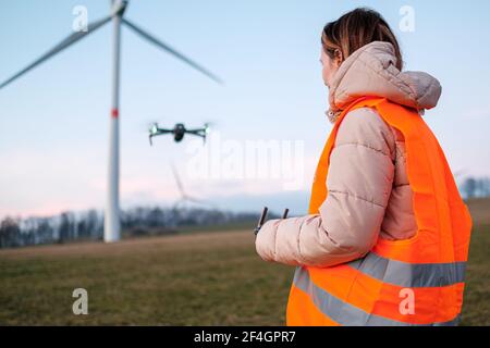 Technician engineer controls wind turbines using a drone. Production of green energy. Generation of power energy. Stock Photo