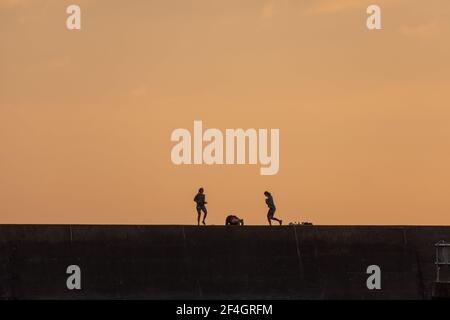 People enjoying the last of the sunshine on the first weekend of the year in Aberystwyth, Wales. Stock Photo