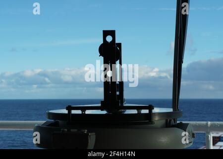 Close up view on the gyro compass repeater with azimuth ring. Pacific Ocean and cumulus clouds in the Backgrounds. Stock Photo