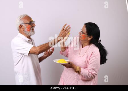 indian senior or old aged couple celebrating holi with colour Stock Photo