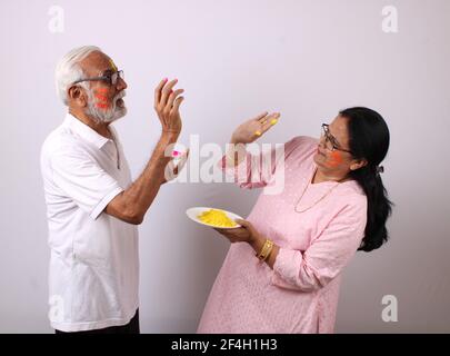 indian senior or old aged couple celebrating holi with colour Stock Photo