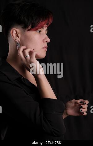 Half length portrait of pretty young adult brunette isolated on black background looking away, copyspace Stock Photo