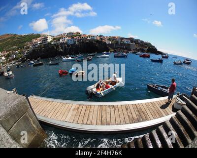 Madeira, Portugal. 09,05,2017     Group of tourists starting a boat trip from the harbour of the village of Camara de Lobos in Madeira. Stock Photo