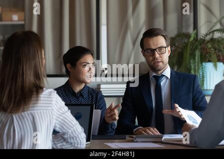Multiethnic colleagues brainstorm over ideas at meeting Stock Photo