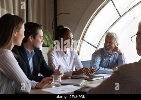 Multiracial businesspeople discuss business ideas at meeting Stock Photo