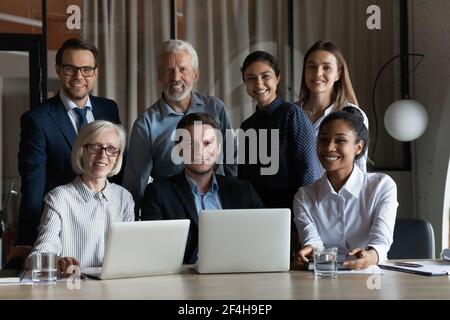 Portrait of smiling multiethnic employees working on computers Stock Photo