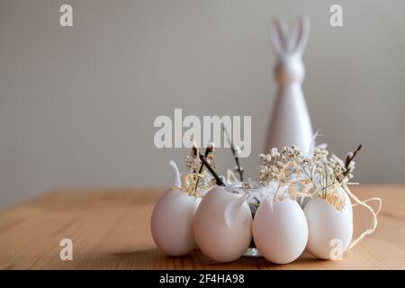 Easter bunny in the background with white eggs in the foreground as a decoration idea for Easter. Landscape format. Stock Photo