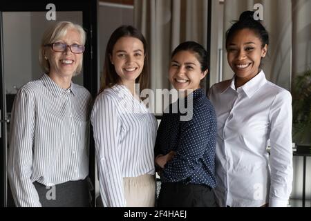 Portrait of smiling multiracial female colleagues pose together Stock Photo