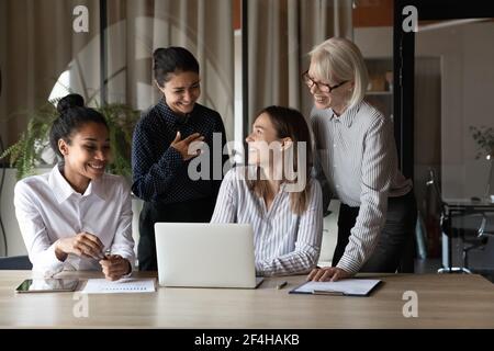 Smiling female employees laugh working at meeting Stock Photo