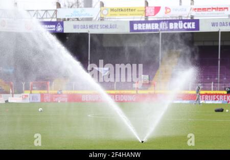 21 March 2021, Lower Saxony, Osnabrück: Football: 2nd Bundesliga, VfL Osnabrück - FC St. Pauli, Matchday 26 at the Stadion an der Bremer Brücke. The grass in the stadium is watered before the start of the match. Photo: Friso Gentsch/dpa - IMPORTANT NOTE: In accordance with the regulations of the DFL Deutsche Fußball Liga and/or the DFB Deutscher Fußball-Bund, it is prohibited to use or have used photographs taken in the stadium and/or of the match in the form of sequence pictures and/or video-like photo series. Stock Photo
