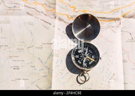 From above of retro compass placed on paper map showing concept of navigation and traveling Stock Photo