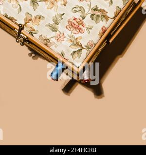Top view of spools of cotton threads placed inside box with floral ornament on brown background Stock Photo